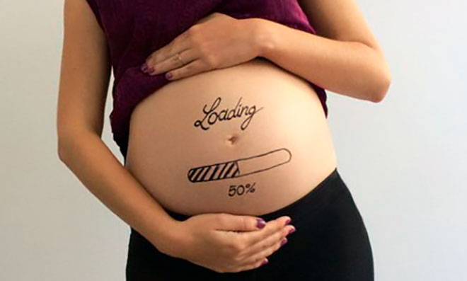 у беременной девушки на животе нарисована шкала загрузки на 50%