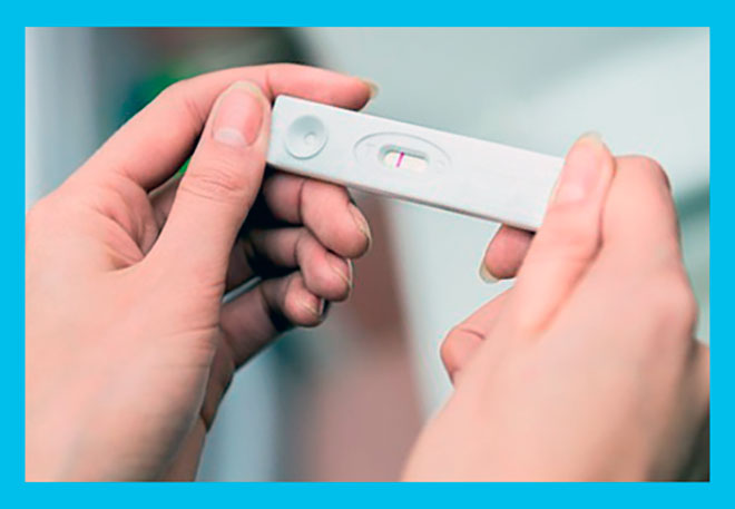 женщина держит в руках отрицательный тест на беременность с одной полоской