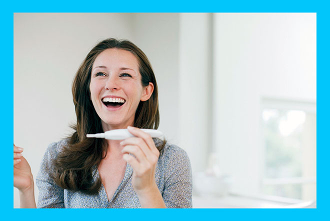 радостная женщина с положительным тестом на беременность