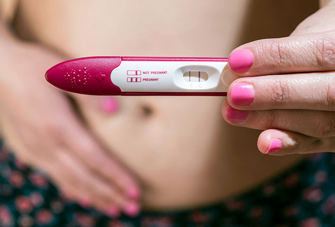 положительный тест на беременность в руках у женщины