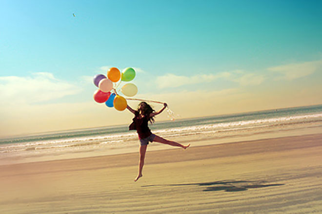 девушка на солнечном пляже с шариками